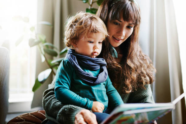 The mother is reading a book to the child